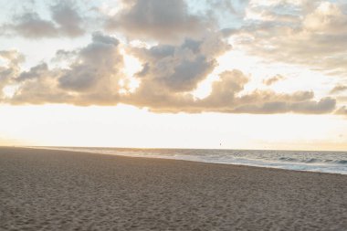 Altın saatlerdeki deniz ve kumlu sahilin arkaplan görüntüleri.