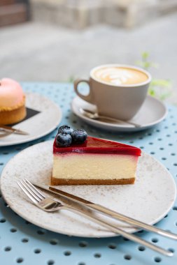 Kaldırımdaki kafede masada iki fincan kapuçino ve tatlılar..
