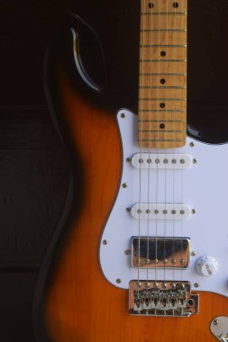 Siyah ahşap arka plana karşı lüks ve büyüleyici bir gitar.