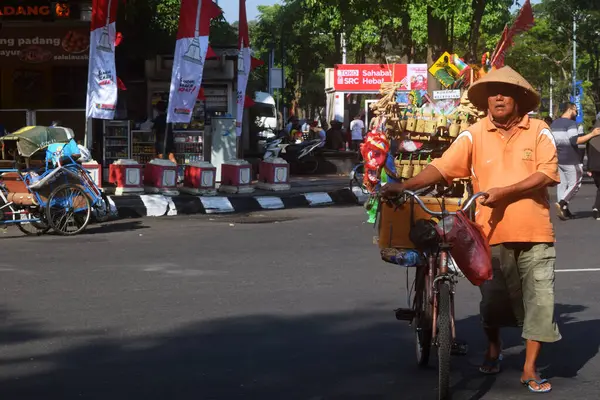 stock image Semarang, Indonesia : May 21, 2023 : An old man brings children's toys to sell at Simpang Lima on a bicycle