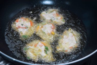 Çiğ sebze ve buğday unu karıştırma süreci Endonezya 'da bir kızartma tavasında kızgın yağda kızartılır.