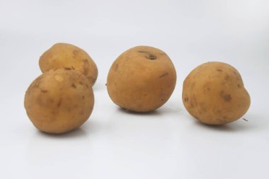 İzole edilmiş beyaz arka planda birkaç çiğ patatesin yakın plan fotoğrafı.