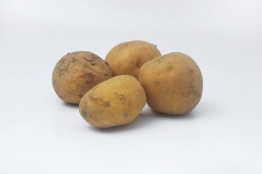 İzole edilmiş beyaz arka planda birkaç çiğ patatesin yakın plan fotoğrafı.