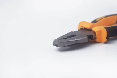 İzole edilmiş beyaz bir arka planda sarı saplı pense çifti yakın plan fotoğrafı.