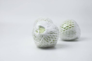 Yeşil guava meyvesi meyve ambalajı ve plastikle kaplıdır. Guava meyvesi beyaz bir arkaplanda.