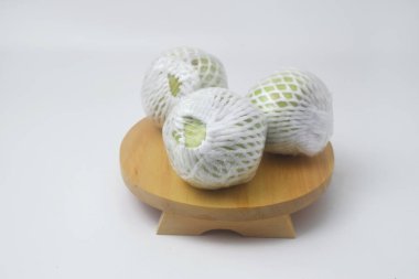 Yeşil guava meyvesi meyve ambalajı ve plastikle kaplıdır. Guava meyvesi beyaz bir arkaplanda.