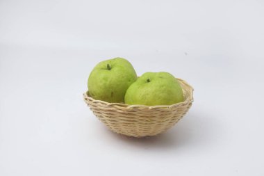 Yeşil guavalar izole edilmiş beyaz arka planda bir meyve sepetinde.