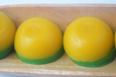 Ahşap bir kasede yuvarlak sarı katmanlı kek geleneksel Endonezya yemeğidir. Arkaplan izole edilmiş beyaz
