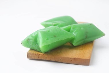 Kue Jentik Manis adı verilen tipik bir Endonezya aperatifi ahşap bir bardak altlığı üzerindedir. İzole edilmiş beyaz arkaplan