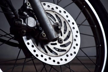 Yakın plan fotoğraf. Fren diski bir motosikletin ön tekerleğinde.