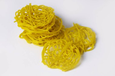 Top view of several yellow raw noodle crackers on an isolated white background clipart