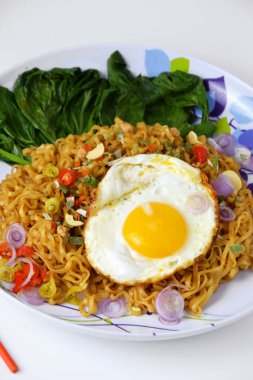 Güneşte kızartılmış eriştenin yakın plan fotoğrafı yumurta ve izole edilmiş beyaz arka planda karışık sebzeler.