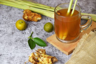 Beton arka planda cam bir fincanda limon ve bal karışımı sağlıklı, sıcak, zencefil içeceği.