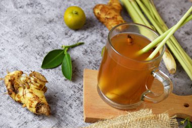 Beton arka planda cam bir fincanda limon ve bal karışımı sağlıklı, sıcak, zencefil içeceği.