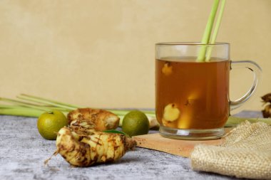 Beton arka planda cam bir fincanda limon ve bal karışımı sağlıklı, sıcak, zencefil içeceği.