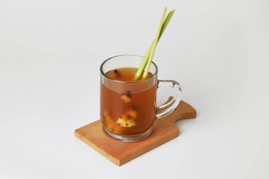 Sıcak kırmızı zencefilli içecek. Bardakta, ahşap altlık ve izole beyaz arka plan. Sağlıklı içecekler tedavi için kullanılabilir.