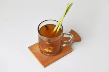 Sıcak kırmızı zencefilli içecek. Bardakta, ahşap altlık ve izole beyaz arka plan. Sağlıklı içecekler tedavi için kullanılabilir.