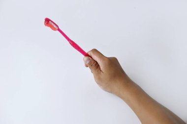 Beyaz izole bir zemin üzerinde diş macunu içeren kırmızı ve beyaz bir diş fırçası tutan bir erkek el.