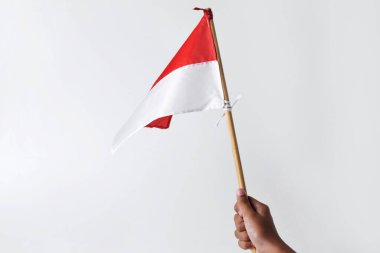 Bir çocuğun eli Endonezya ulusunun kırmızı ve beyaz bayrağını tutuyor ve sallıyor.