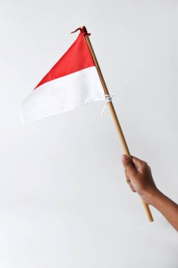 Bir çocuğun eli Endonezya ulusunun kırmızı ve beyaz bayrağını tutuyor ve sallıyor.