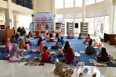 Tegal, Indonesia - July 28, 2024 : A judge gave an explanation to the children regarding the coloring competition at the Brebes City Library clipart