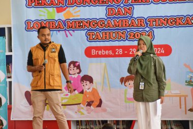 Tegal, Endonezya - 28 Temmuz 2024: Brebes Şehir Kütüphanesi 'ndeki renk yarışmasıyla ilgili bir yargıç çocuklara açıklama yaptı