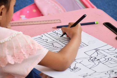 Brebes şehir kütüphanesindeki resim ve boyama yarışmasında küçük bir kız çizim yapıyor.