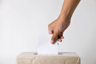 Oy pusulasını karton bir sandığa sokan ellerin yakın plan fotoğrafı. Seçim konsepti. izole edilmiş beyaz arkaplan