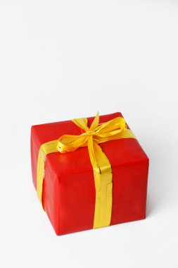 Noel ve yeni yıl için sarı kurdeleli kırmızı hediye kutusunun portresi. beyaz izolasyon arka planı