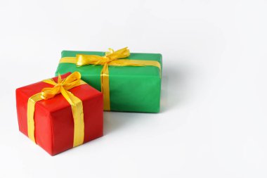 Sarı kurdeleli iki kırmızı ve yeşil hediye kutusu beyaz izole bir arka planda. Noel günü ve yeni yıl için hediye sembolü