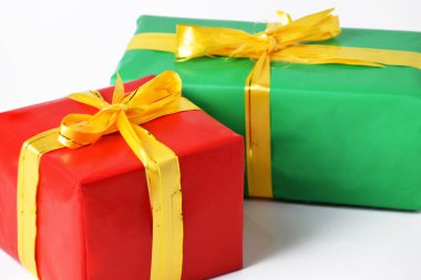 Sarı kurdeleli iki kırmızı ve yeşil hediye kutusu beyaz izole bir arka planda. Noel günü ve yeni yıl için hediye sembolü