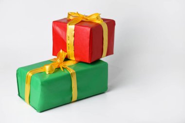 Altın sarısı kurdeleli kırmızı ve yeşil hediye kutusu beyaz izole arka planda. Noel ve Yeni Yıl için hediyeler