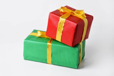 Altın sarısı kurdeleli kırmızı ve yeşil hediye kutusu beyaz izole arka planda. Noel ve Yeni Yıl için hediyeler