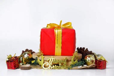 Canlı bir görüntü, küçük ahşap bir platforma yerleştirilmiş altın kurdeleli kırmızı bir hediye kutusu gösteriyor..