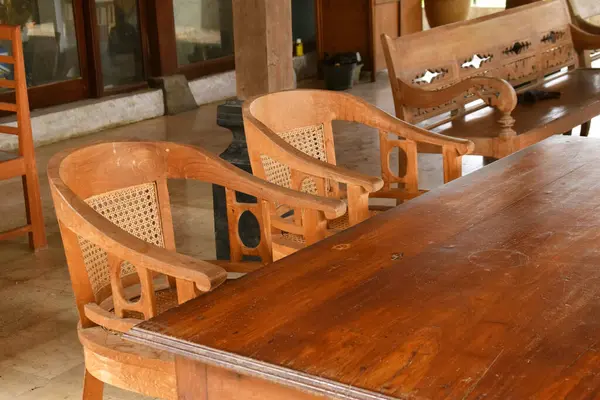 Yuvarlak mermer bir masanın etrafını saran dört adet antik ahşap sandalye. Otantik Cava kültürel tasarımı sergileniyor.