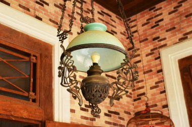 Yakın plan bir antika, Java süslemeli lamba, camsı bir gölgesi var..