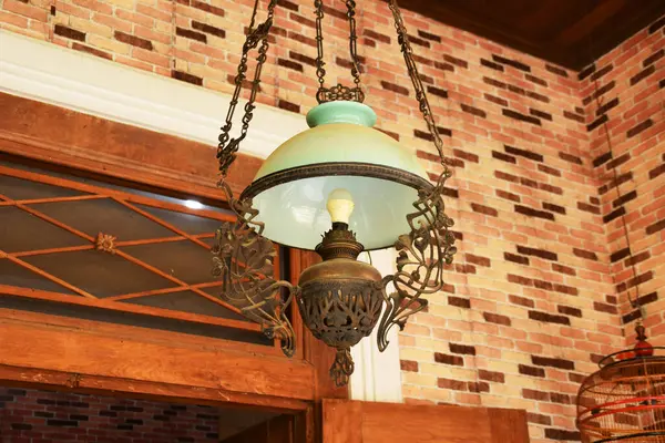 Yakın plan bir antika, Java süslemeli lamba, camsı bir gölgesi var..