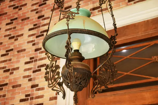 Yakın plan bir antika, Java süslemeli lamba, camsı bir gölgesi var..