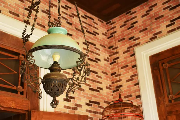 Yakın plan bir antika, Java süslemeli lamba, camsı bir gölgesi var..