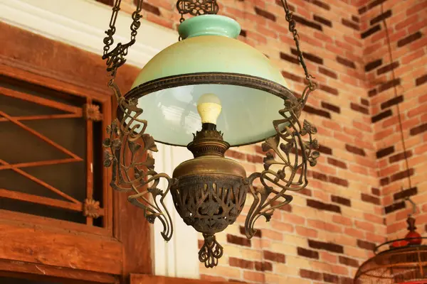 Yakın plan bir antika, Java süslemeli lamba, camsı bir gölgesi var..