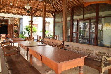 Pekalongan, Endonezya - 26 Aralık 2024: Pekalongan, Endonezya 'da geleneksel bir Java pendopo evinin atmosferi, ahşap mobilyalar, dekoratif oymalar ve açık, geniş bir yerleşim alanı.