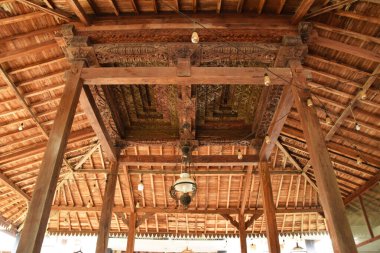 Pekalongan, Endonezya - 26 Aralık 2024: Pekalongan, Endonezya 'da geleneksel bir Java pendopo evinin atmosferi, ahşap mobilyalar, dekoratif oymalar ve açık, geniş bir yerleşim alanı.