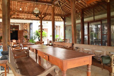 Pekalongan, Endonezya - 26 Aralık 2024: Pekalongan, Endonezya 'da geleneksel bir Java pendopo evinin atmosferi, ahşap mobilyalar, dekoratif oymalar ve açık, geniş bir yerleşim alanı.