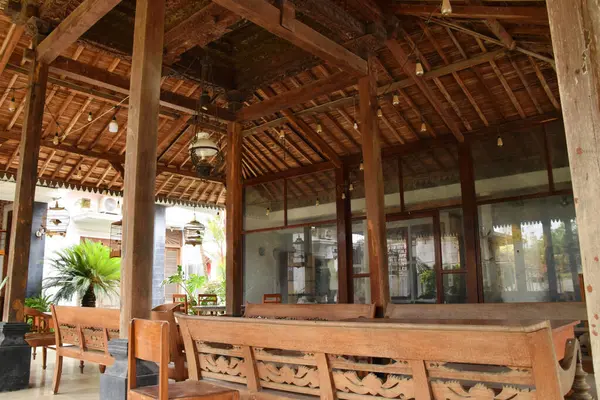 Pekalongan, Endonezya - 26 Aralık 2024: Pekalongan, Endonezya 'da geleneksel bir Java pendopo evinin atmosferi, ahşap mobilyalar, dekoratif oymalar ve açık, geniş bir yerleşim alanı.