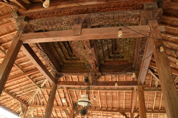 Pekalongan, Endonezya - 26 Aralık 2024: Pekalongan, Endonezya 'da geleneksel bir Java pendopo evinin atmosferi, ahşap mobilyalar, dekoratif oymalar ve açık, geniş bir yerleşim alanı.