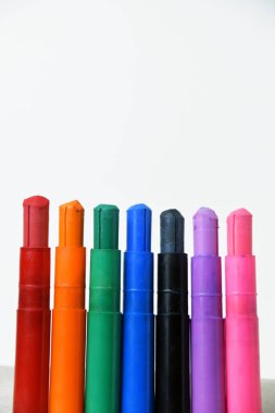 Temiz beyaz bir arkaplanda renkli ipek renkli renkli boya çubukları.