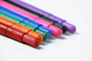 Beyaz arka planda canlı ipek renkli boya kalemleri. Resim, sanat projeleri ve okul malzemeleri için renkli mum kalemler..