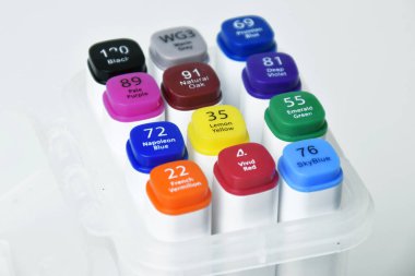 Beyazların izole edilmiş arkaplanı, eğitim ve yaratıcı projeler için ideal olan çeşitli renkli kalemlerin yakın görüntüsü.