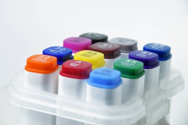 Beyazların izole edilmiş arkaplanı, eğitim ve yaratıcı projeler için ideal olan çeşitli renkli kalemlerin yakın görüntüsü.