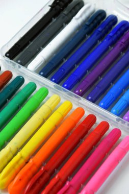 Renklendirmek için tasarlanmış renkli ipek boya kalemlerinin beyaz izole bir arka planda yakın plan görüntüsü..